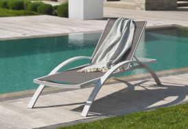 Bain de soleil blanc en aluminium et textilène au bord de la piscine